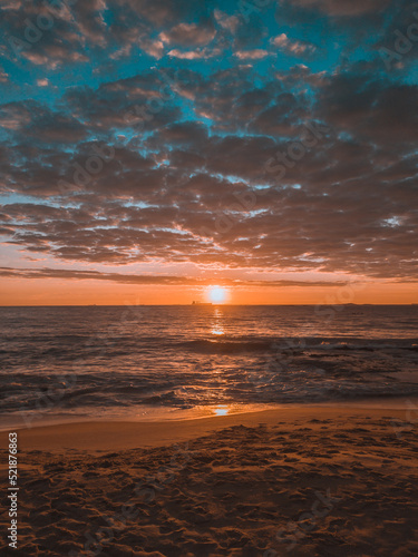 Fototapeta Naklejka Na Ścianę i Meble -  Nascer do sol no mar de Vila Velha no Espírito santo. Céu dourado e azul e reflexo do sol no mar.