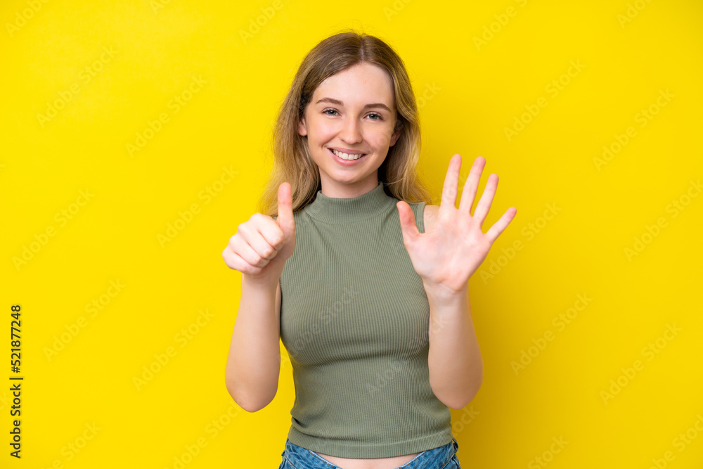 Blonde English young girl isolated on yellow background counting six with fingers Blonde English young girl isolated on yellow background counting six with fingers