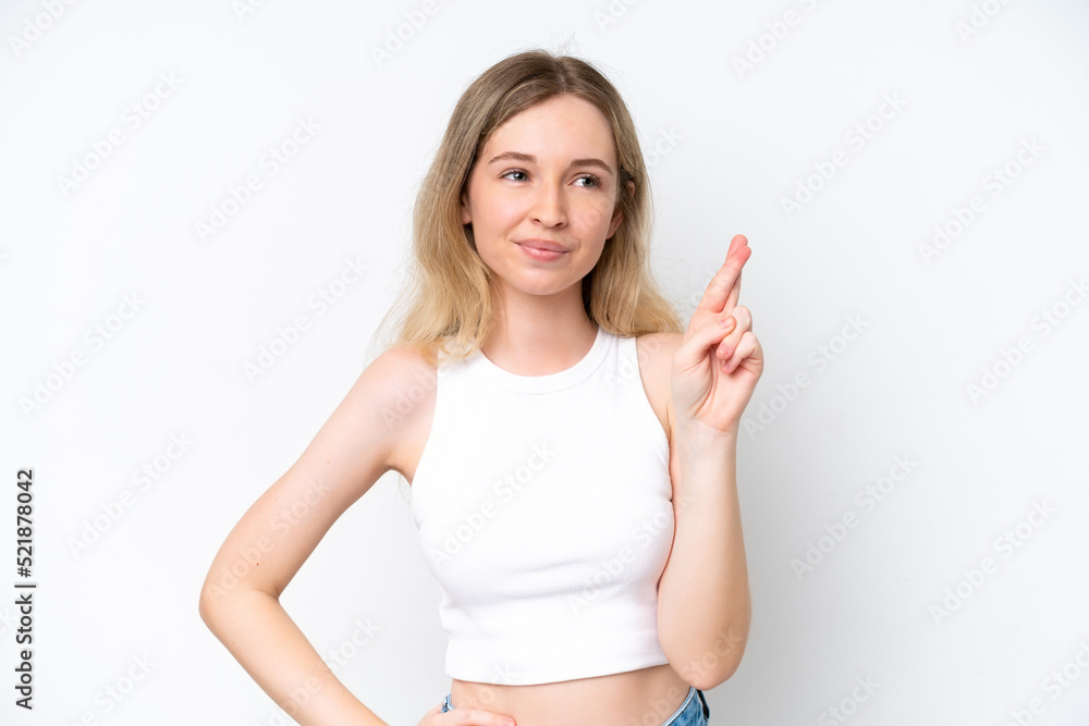 Blonde English young girl isolated on white background with fingers crossing and wishing the best Blonde English young girl isolated on white background with fingers crossing and wishing the best