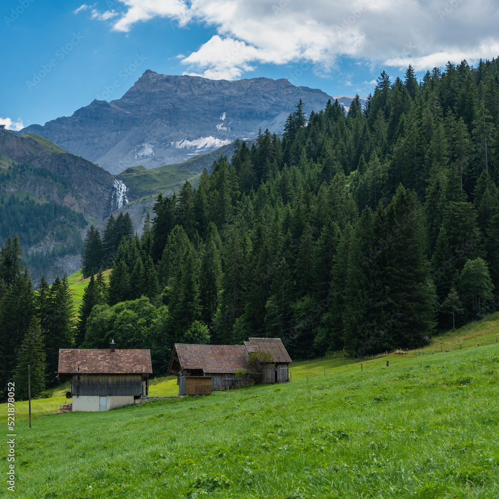 alte Bauernhäuser aus Holz im Boden, Adelboden. Streusiedlung mit Wiesen und Wäldern in den schweizer Alpen. Berge im Hintergrund alte Bauernhäuser aus Holz im Boden, Adelboden. Streusiedlung mit Wiesen und Wäldern in den schweizer Alpen. Berge im Hintergrund