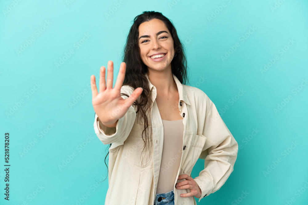 Young caucasian woman isolated on blue background counting five with fingers