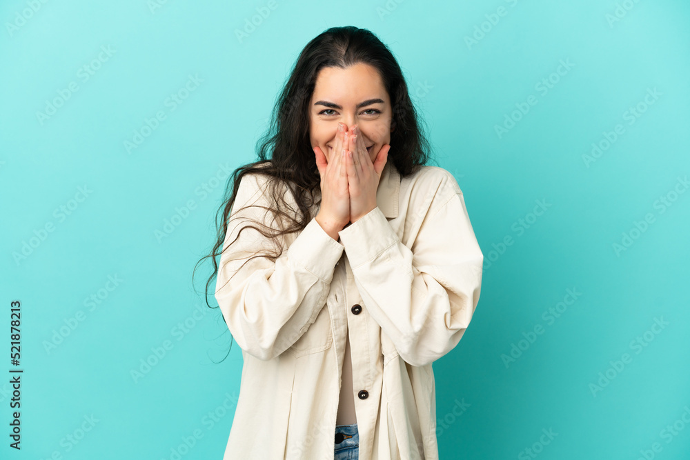 Young caucasian woman isolated on blue background happy and smiling covering mouth with hands Young caucasian woman isolated on blue background happy and smiling covering mouth with hands