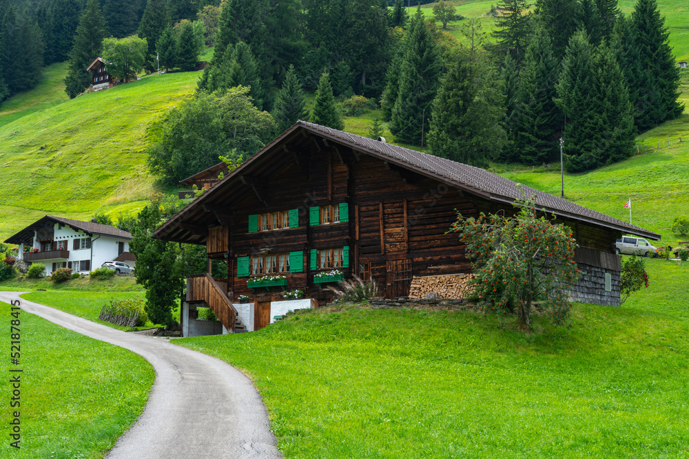 alte Bauernhäuser aus Holz im Boden, Adelboden. Streusiedlung mit Wiesen und Wäldern in den schweizer Alpen. Berge im Hintergrund alte Bauernhäuser aus Holz im Boden, Adelboden. Streusiedlung mit Wiesen und Wäldern in den schweizer Alpen. Berge im Hintergrund