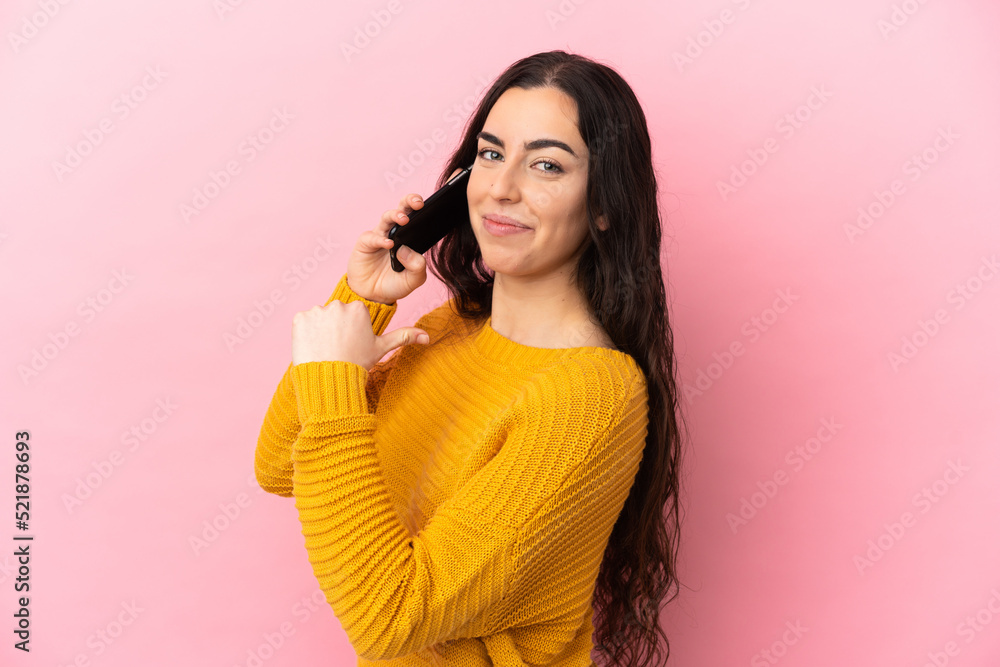 Young caucasian woman using mobile phone isolated on pink background proud and self-satisfied Young caucasian woman using mobile phone isolated on pink background proud and self-satisfied