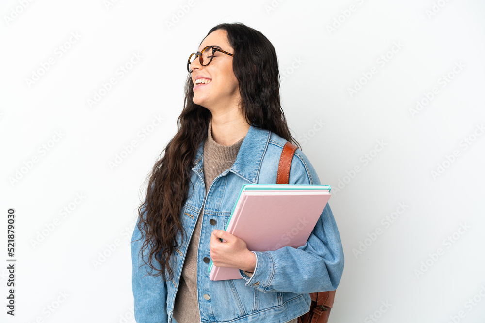 Fototapeta premium Young student woman isolated on white background laughing in lateral position