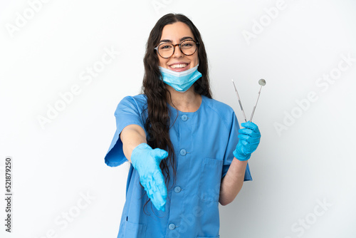 Young woman dentist holding tools isolated on white background shaking hands for closing a good deal