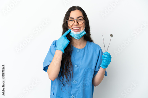 Young woman dentist holding tools isolated on white background giving a thumbs up gesture