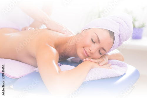Young smiling woman getting back massage in massage salon