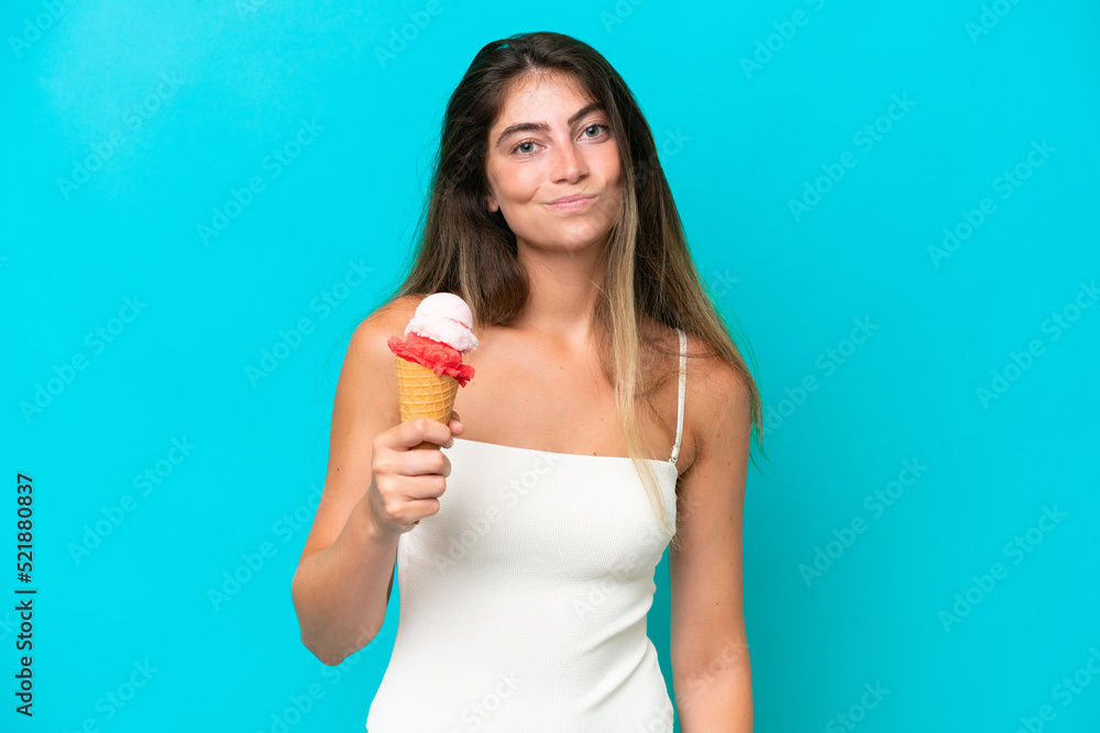Young woman in swimsuit holding an ice cream isolated on blue background with sad expression Young woman in swimsuit holding an ice cream isolated on blue background with sad expression
