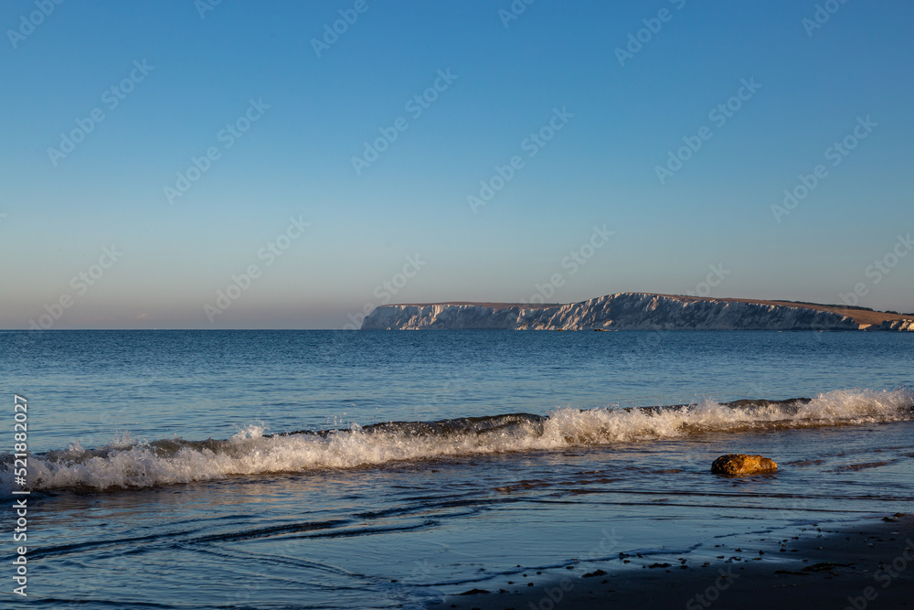 An early morning view over the ocean towards the chalk cliffs at Freshwater Bay, on the Isle of Wight