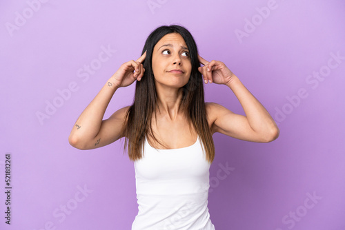 Young caucasian woman isolated on purple background having doubts and thinking © luismolinero