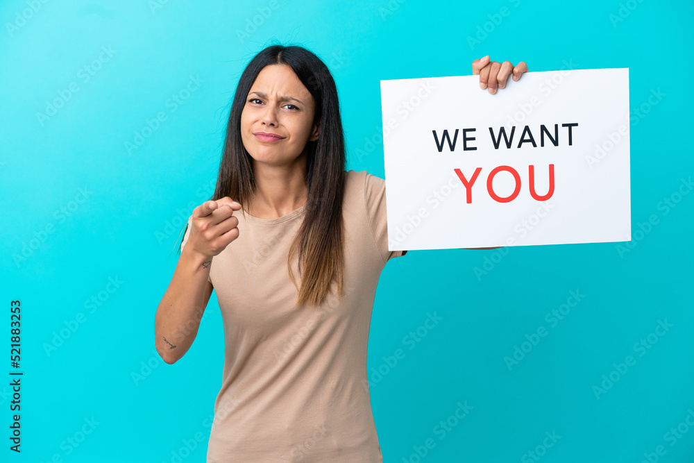 Young woman over isolated background holding We Want You board and pointing to the front Young woman over isolated background holding We Want You board and pointing to the front