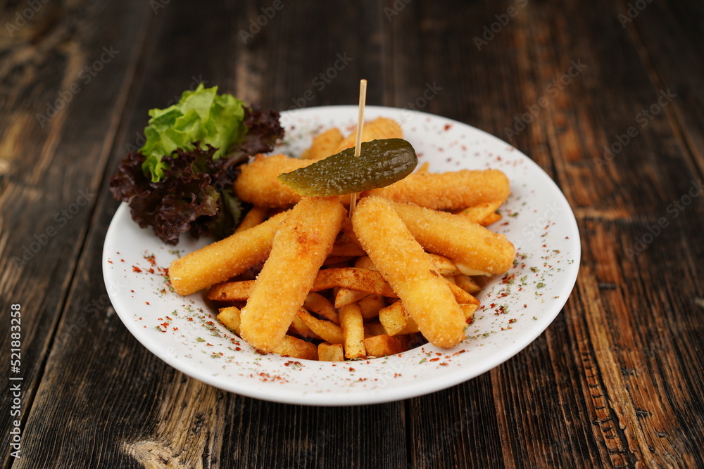 Potato croquettes with french fries on the white plate. Delicious unhealthy appetizer. Beer platter on wooden background with pickles. Snack for beer or drink. Potato croquettes with french fries on the white plate. Delicious unhealthy appetizer. Beer platter on wooden background with pickles. Snack for beer or drink.