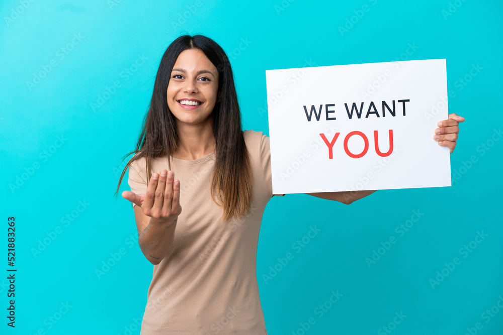 Young woman over isolated background holding We Want You board and doing coming gesture Young woman over isolated background holding We Want You board and doing coming gesture