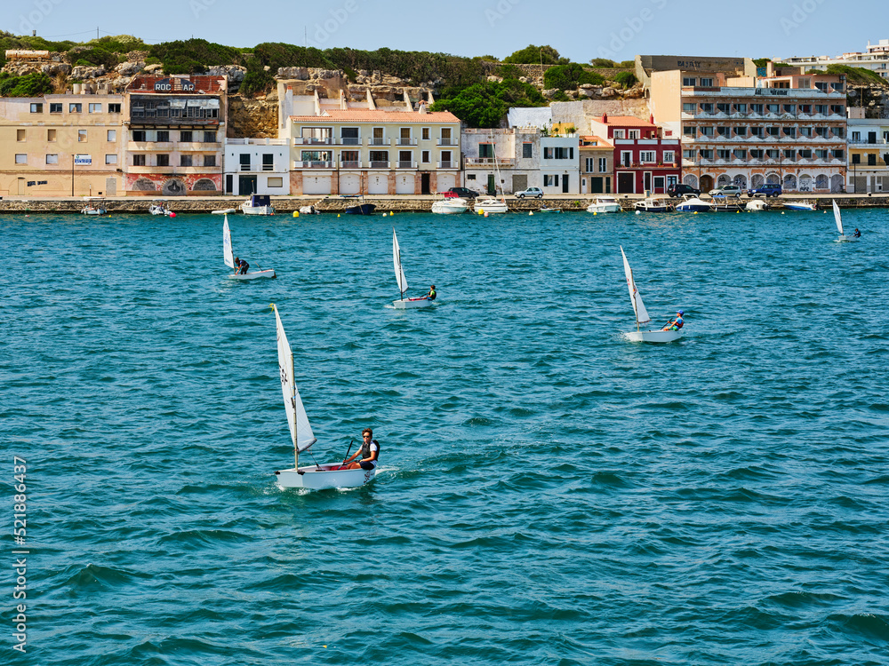 Five small sailboats for one at sea near the coast of Menorca, Spain