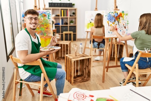 Group of people drawing at art studio. Man smiling happy looking to the camera.