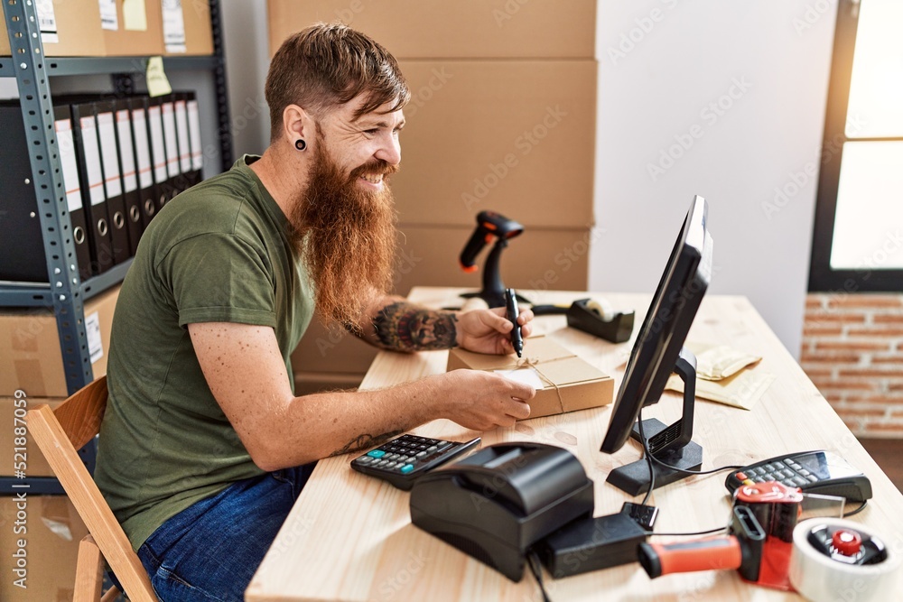 Young redhead man business worker prepare order package at office Young redhead man business worker prepare order package at office