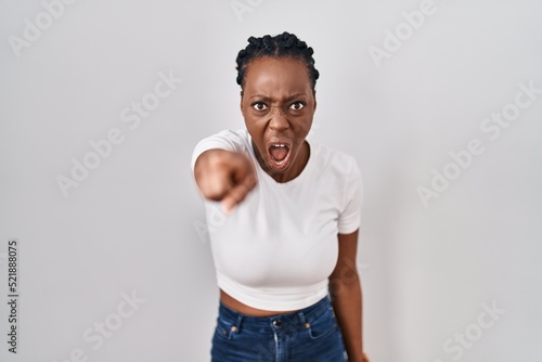 Принти на полотні Beautiful black woman standing over isolated background pointing displeased and