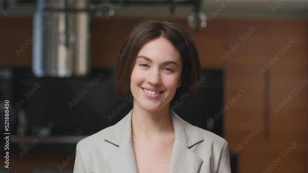 Female businessperson real estate agent smiling standing in new modern apartment, headshot portrait. Lock shot Female businessperson real estate agent smiling standing in new modern apartment, headshot portrait. Lock shot