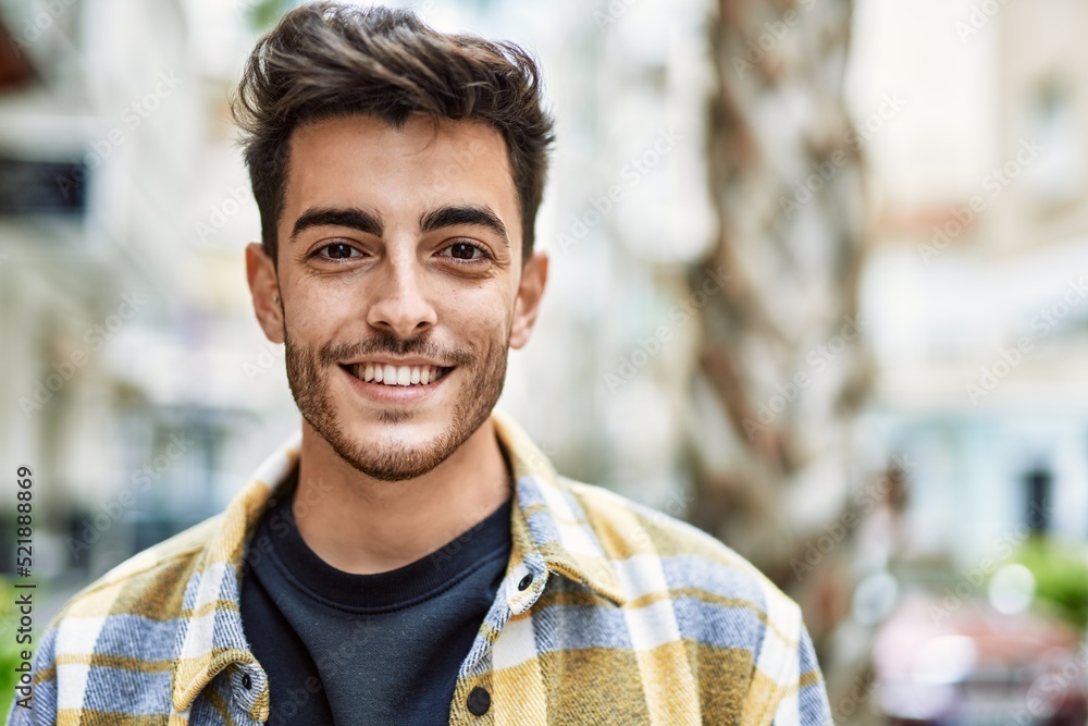 Fototapeta premium Handsome hispanic man smiling happy and confident at the city