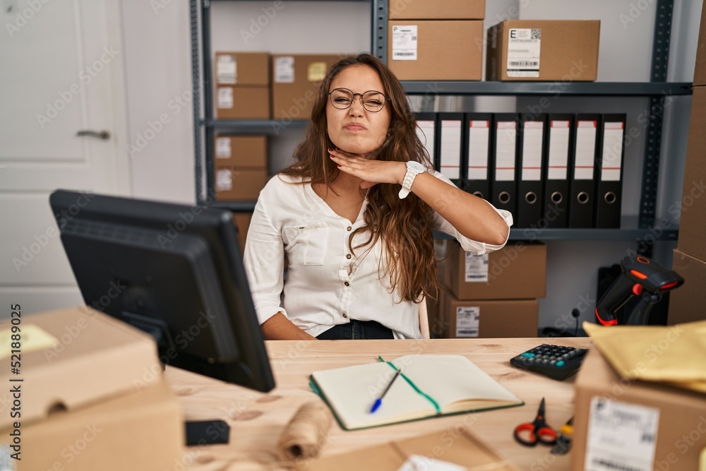 Young hispanic woman working at small business ecommerce cutting throat with hand as knife, threaten aggression with furious violence Young hispanic woman working at small business ecommerce cutting throat with hand as knife, threaten aggression with furious violence