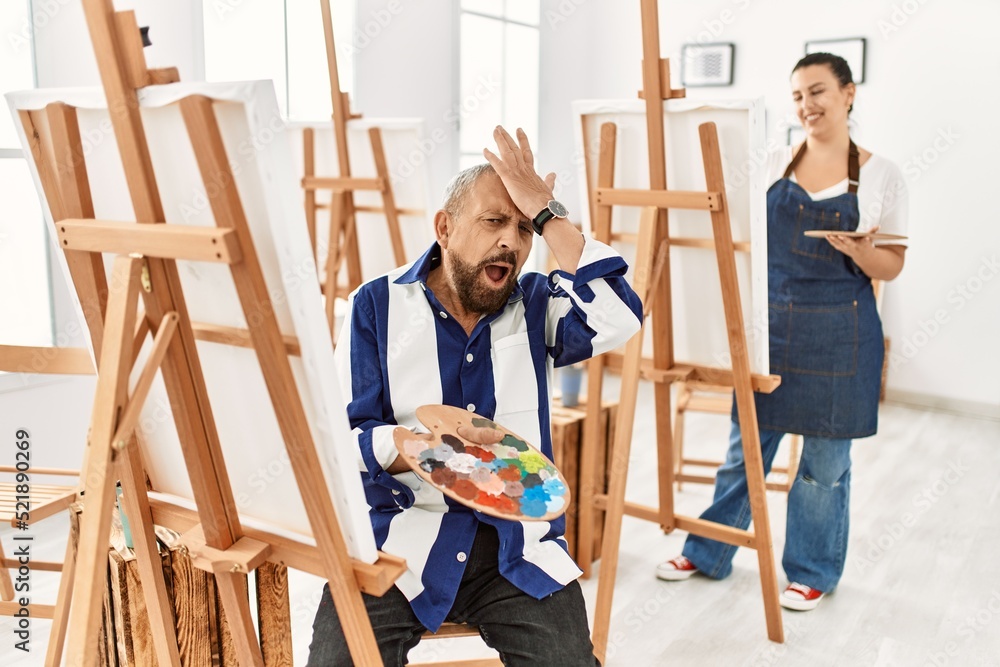 Senior artist man at art studio surprised with hand on head for mistake, remember error. forgot, bad memory concept. Senior artist man at art studio surprised with hand on head for mistake, remember error. forgot, bad memory concept.