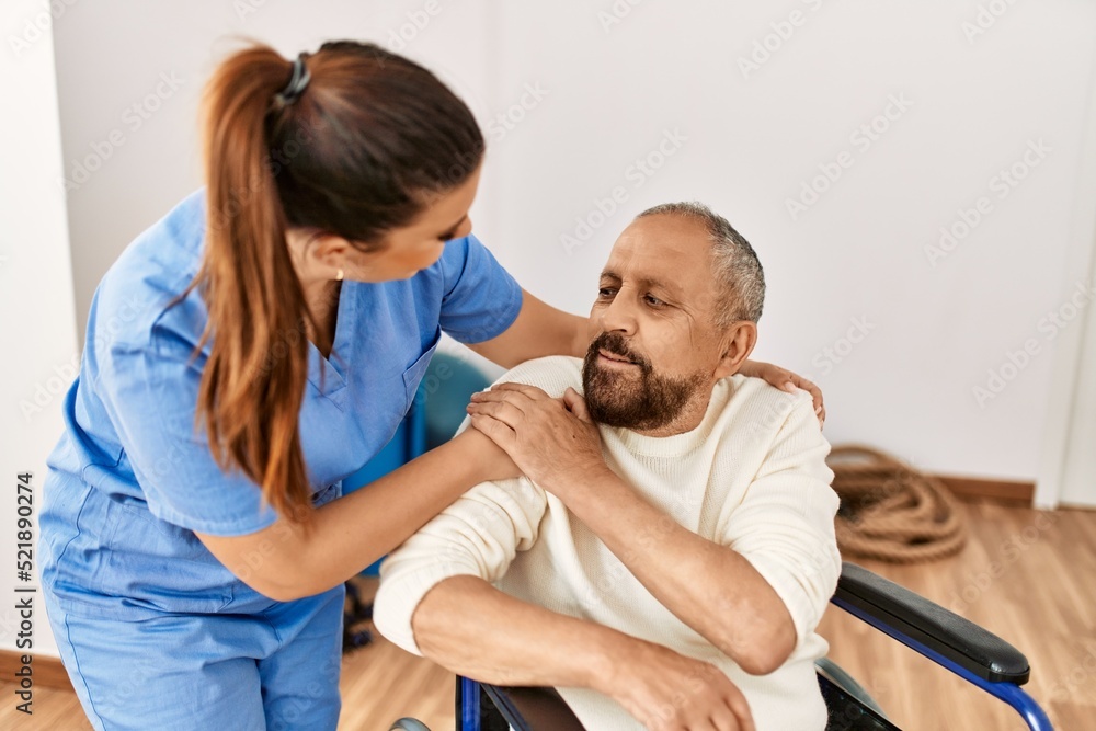 Senior man sitting on wheelchair and geriatric nurse at rehabilitation clinic Senior man sitting on wheelchair and geriatric nurse at rehabilitation clinic