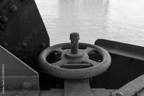 Grayscale shot of a pipe valve photo