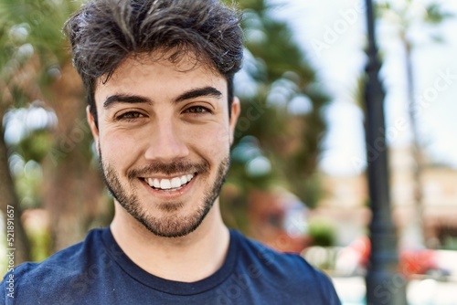 Young hispanic man smiling happy standing at the city.