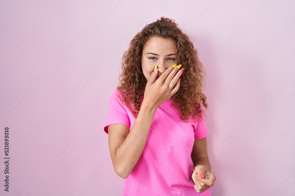 Young caucasian woman standing over pink background smelling something stinky and disgusting, intolerable smell, holding breath with fingers on nose. bad smell Young caucasian woman standing over pink background smelling something stinky and disgusting, intolerable smell, holding breath with fingers on nose. bad smell