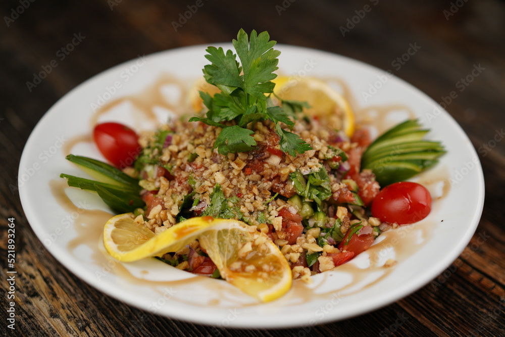 Finely chopped Turkish salad on a wood background. Salad with lemon and parsley. Salad made with fresh vegetables. Finely chopped Turkish salad on a wood background. Salad with lemon and parsley. Salad made with fresh vegetables.