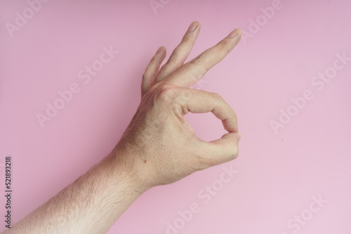 Bild auf Leinwand Mano haciendo gesto de aprobación, ok,  sobre fondo rosa.