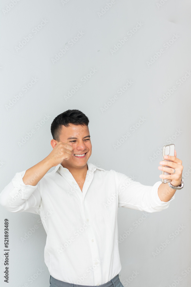 Chico latino empresariosonriente videollama a socio por el smartphone posa para una foto grupal
