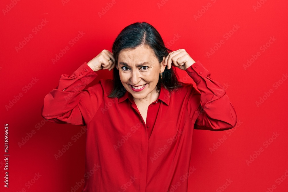 Middle age hispanic woman wearing casual clothes smiling pulling ears with fingers, funny gesture. audition problem Middle age hispanic woman wearing casual clothes smiling pulling ears with fingers, funny gesture. audition problem