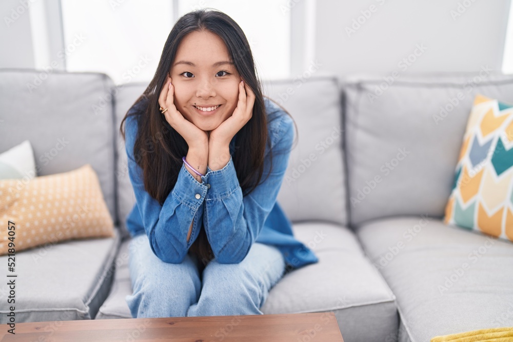 Young chinese woman smiling confident sitting on sofa at home Young chinese woman smiling confident sitting on sofa at home