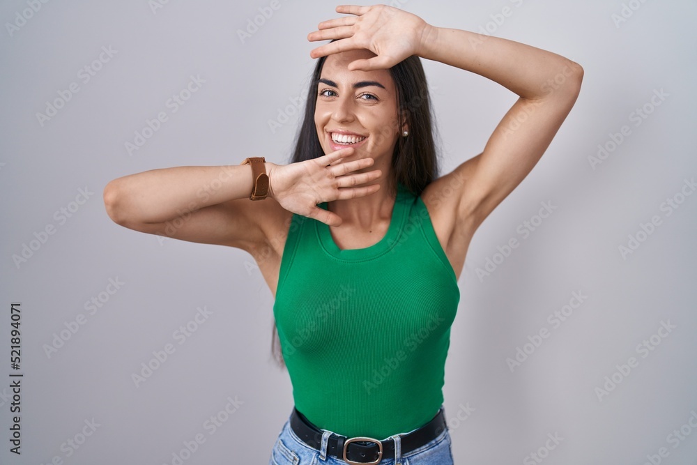 Young woman standing over isolated background smiling cheerful playing peek a boo with hands showing face. surprised and exited Young woman standing over isolated background smiling cheerful playing peek a boo with hands showing face. surprised and exited