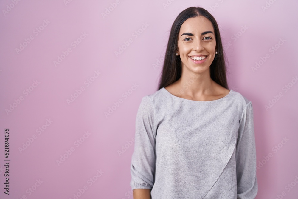 Young brunette woman standing over pink background with a happy and cool smile on face. lucky person. Young brunette woman standing over pink background with a happy and cool smile on face. lucky person.