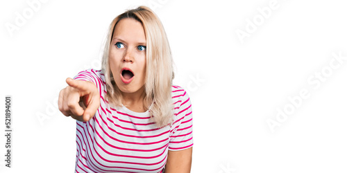 Young caucasian woman wearing casual clothes pointing with finger surprised ahead, open mouth amazed expression, something on the front