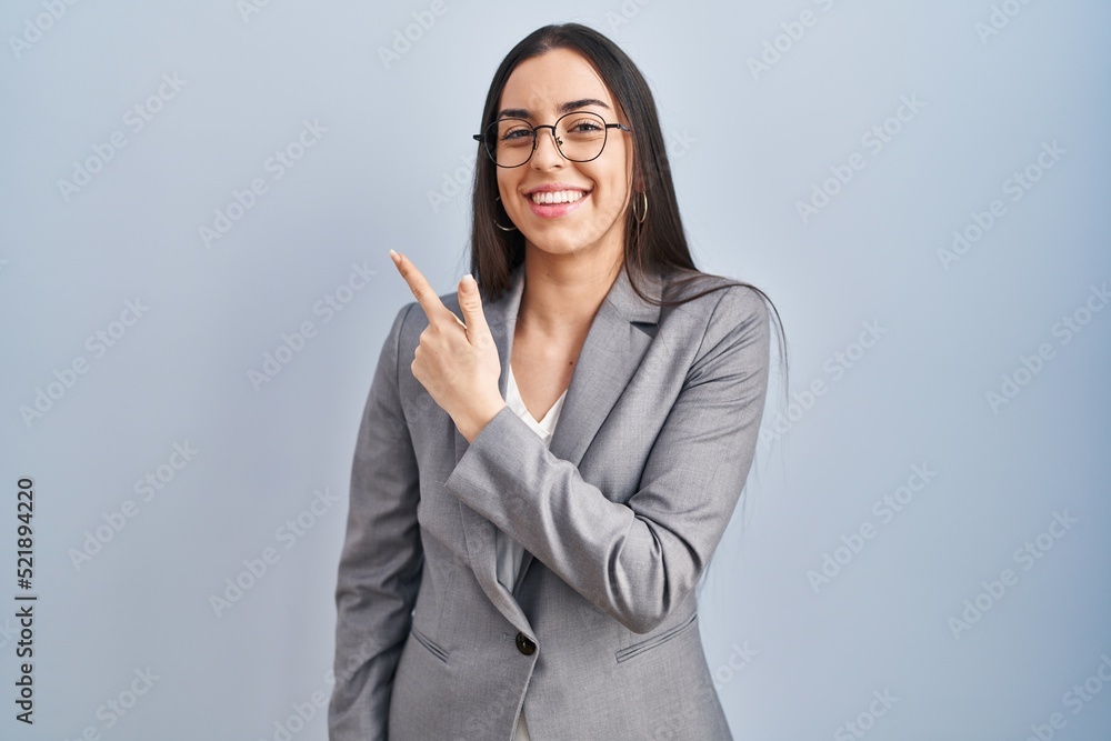 Hispanic business woman wearing glasses cheerful with a smile of face pointing with hand and finger up to the side with happy and natural expression on face Hispanic business woman wearing glasses cheerful with a smile of face pointing with hand and finger up to the side with happy and natural expression on face