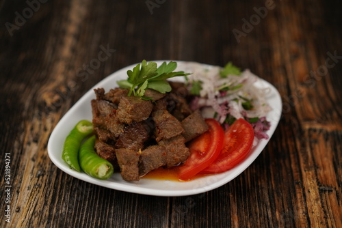 Traditional Turkish food ciger with onion, tomatoes and green pepper. Ciger made with beef liver. Beef liver marinated with milk and cooked in oil. Traditional street food in Turkey.