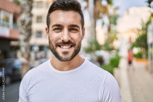 Young hispanic man smiling confident walking at street