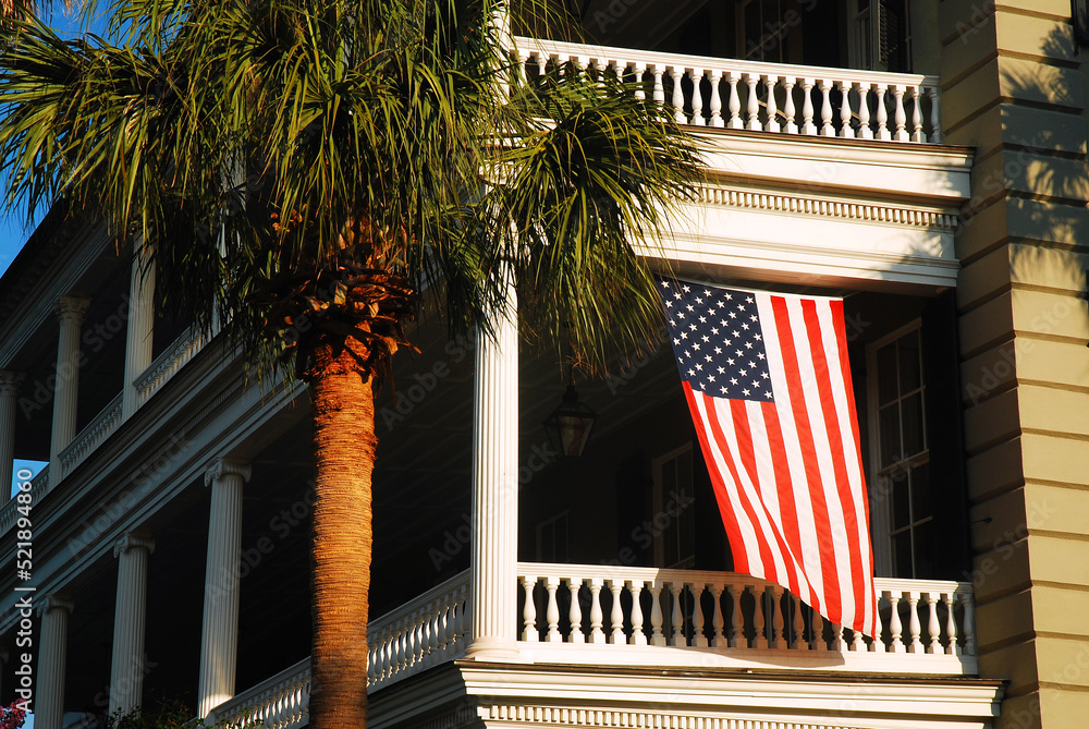 Fototapeta premium American Flag Hangs from a Balcony, of an Antebellum manor in Charleston SC