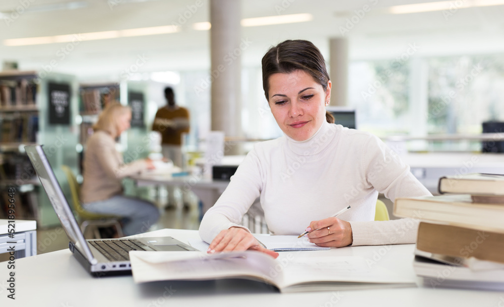 Fototapeta premium Successful woman studying in the library. High quality photo