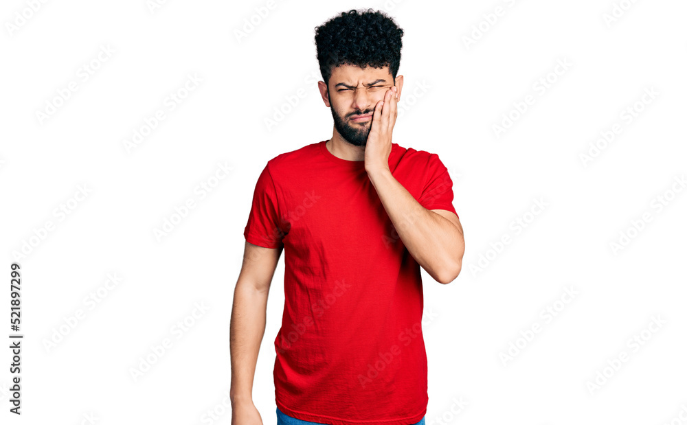 Young arab man with beard wearing casual red t shirt touching mouth with hand with painful expression because of toothache or dental illness on teeth. dentist Young arab man with beard wearing casual red t shirt touching mouth with hand with painful expression because of toothache or dental illness on teeth. dentist