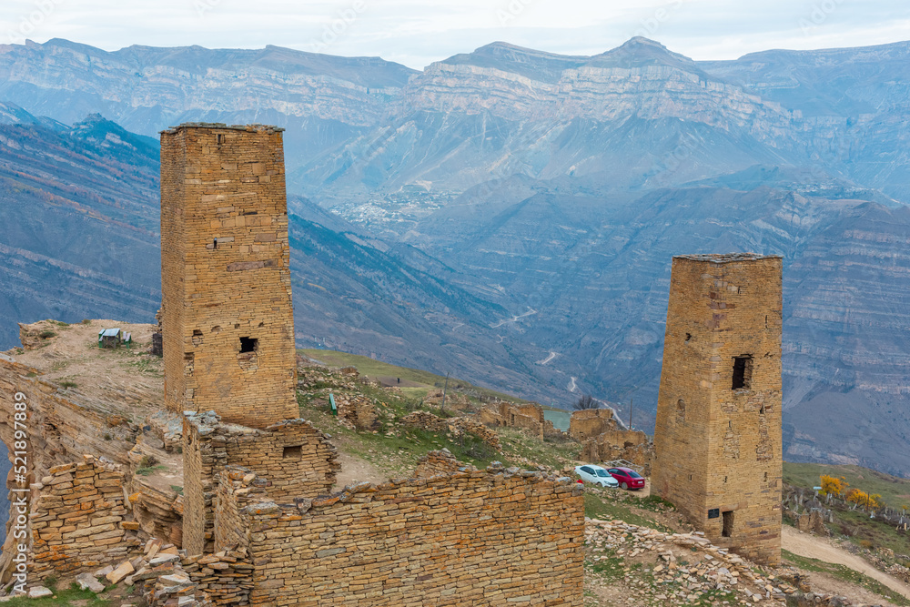 Towers of the abandoned village of Goor, Dagestan, Russia. Stone towers on the rocks and blue sky on the background. Panoramic view of the Caucasus Mountains