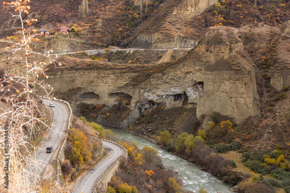 Serpentine road to the village of Gunib, Dagestan, Russia. A sharp turn in the road. Beautiful highway in autumn in the mountains. Orange landscape