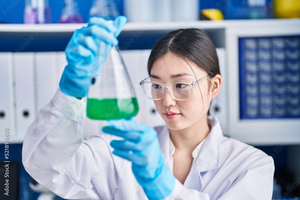 Chinese woman scientist measuring liquid working at laboratory Chinese woman scientist measuring liquid working at laboratory