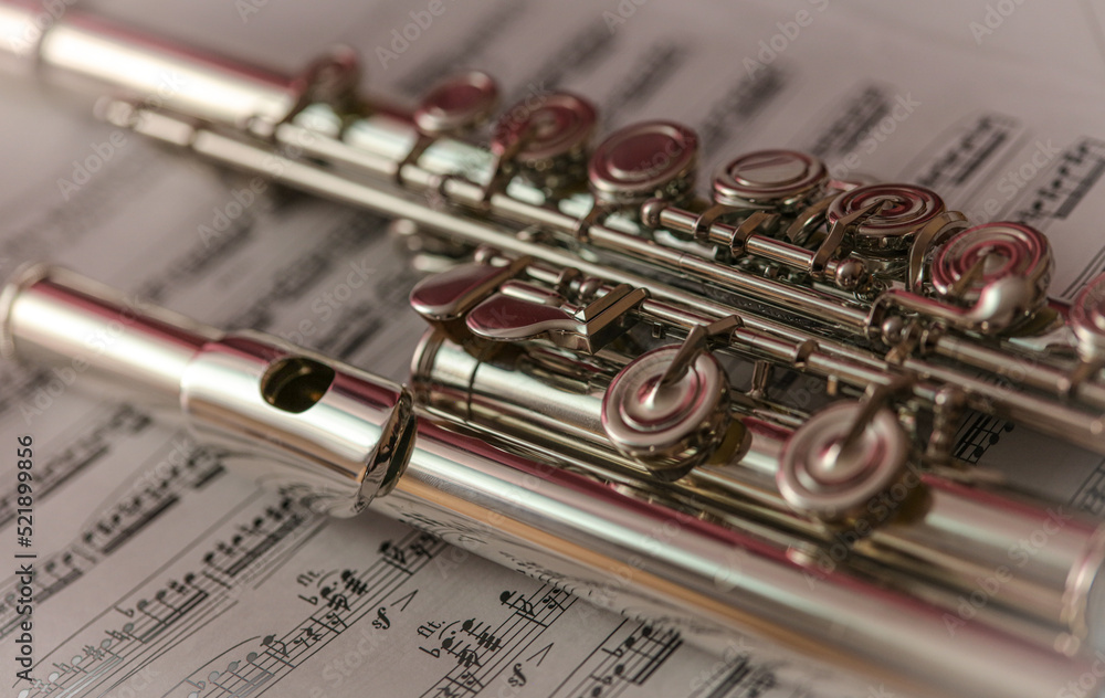 Close up of the flute musical instrument on the music sheet