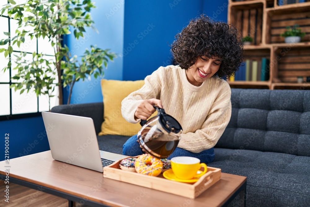 Young middle east woman using laptop having breakfast at home Young middle east woman using laptop having breakfast at home