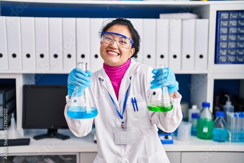 Young asian woman working at scientist laboratory celebrating crazy and amazed for success with open eyes screaming excited.